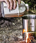 Pouring water from Stainless Steel Canteen Cooking Set For Survival Camping Nestable Mess Kit into cup over open fire