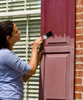 Person applying No Brainer Game Changing Premium Exterior Restorer For Shutters And Outdoor Surfaces That Rejuvenates Faded Color And Lasts Over A Decade Eco Friendly With Included Cleaner And Small Project Kit to a maroon shutter