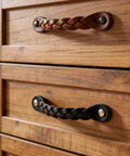 Braided Cognac Leather Drawer Pulls on wooden dresser showcasing the rustic industrial design, part of Leather Drawer Pulls Braided Cognac Finish Set.