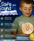 Moon Night Light For Kids Room With Colorful LED Glow held by a smiling child, showing 4.7 inch size and safety certifications.