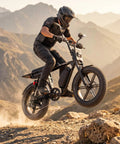 Dual Battery Adult Electric Bike With 956 Wh Juice And A Mean 1800W Motor Logging Ninety Miles on rocky terrain, rider in mid-jump.
