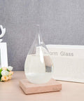 Storm Glass Weather Predictor With Wood Base Modern Weather Station Crystal Glass Bottle For Home Or Office Decor Predict Weather By Crystal Formations Dope Desk Accessory And Conversation Starter on a desk setting