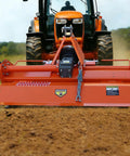 Three Point Rotary Tiller Attachment For 20 To 30HP Tractors 53 Inch Working Width 4.7 Inch Deep PTO Driven At 540 RPM Lightweight Durable Farm Tiller For Yard Work Orange Finish attached to an orange tractor on a dirt field