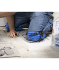 Person using KN-1 Ultralight Knee Pads with maximum comfort and strong grip while working on tiling project, visible blue nonskid outer shell