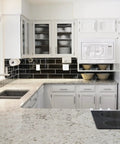 Modern kitchen with white cabinetry and black tile backsplash showcasing Brushed Nickel One Half Inch Overlay Cabinet Hinges Self Closing Semi Wrap Face Frame For Cabinet Doors Fifty Pack Twenty Five Pairs With Screws And Quiet Bumpers For Cupboard And Kitchen Remodel installed on upper cabinets.