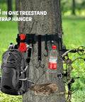 8 In 1 Strap Hangers Kit With Bow Hanger And Multi Hook Gear attached to tree, holding backpack, bow, and bottle.