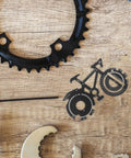 Compact Bicycle Shaped Multitool Keychain Made From Durable Stainless Steel for on-the-go bike repairs on a wooden surface