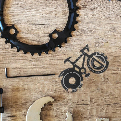 Bicycle Shape Multi Tool Keychain Stainless Steel Compact Bike Repair Kit For Outdoor Cycling Enthusiasts on a wooden table