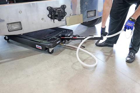 17 Gallon Low Profile Truck Drain With 120V Electric Pump For No Sweat Fluid Cleanup Features 6 Foot Discharge Hose Steel Hook and Heavy Duty Polypropylene Build For Weekend Warriors in use under truck.