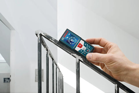 Hand holding GLM 50 C Laser Distance Meter 165 Ft with Backlit Display measuring stair railing