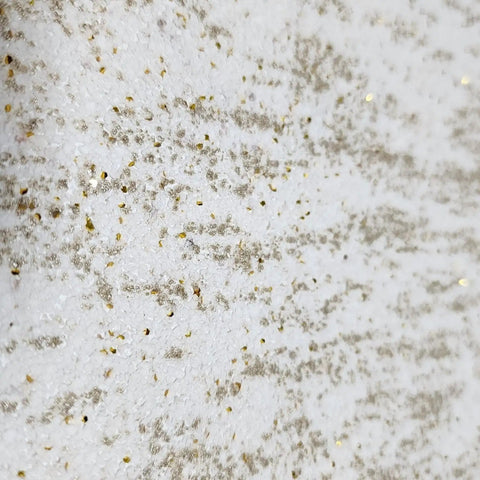 Close-up of Top Shelf Vinyl Textured Wallpaper In Crisp Off White Cream Accented With Shimmery Gold Mica Chips.