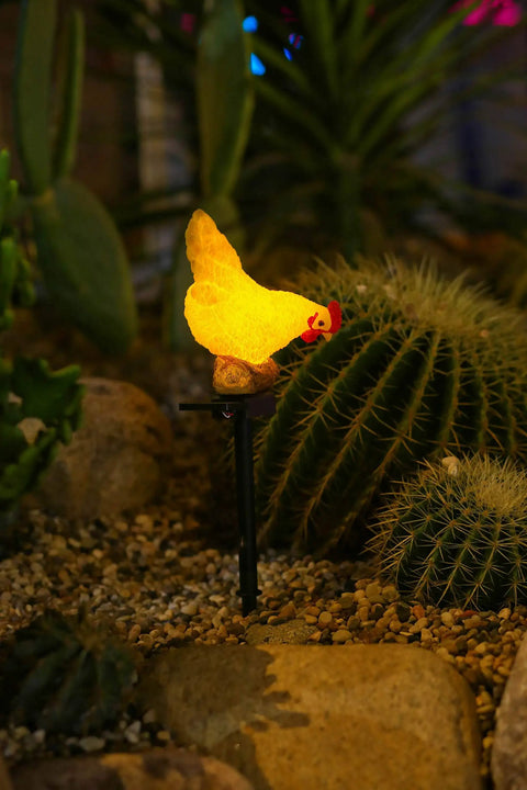 Outdoor Chicken Solar Lights Resin Garden Decor glowing among cactus at night