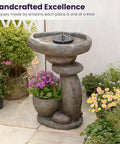 Solar Fountain For Bird Bath And Planter, freestanding rock waterfall with LED lights in a garden setting, featuring plants.
