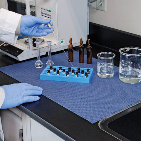 Lab workstation with blue adhesive-backed absorbent mat for industrial floors, 16 W x 25 Ft L, slip-resistant, easy cleanup.