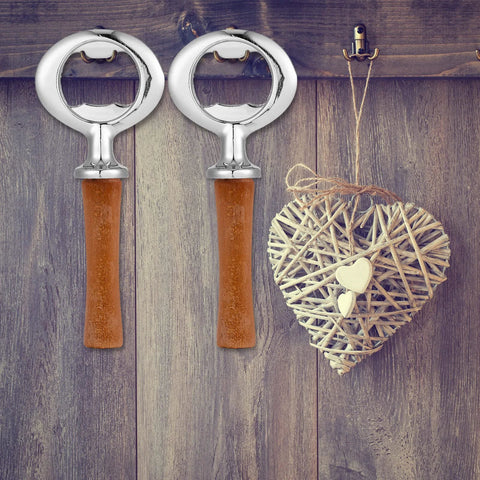 Two Cunhill metal bottle openers with brown wooden handles on a wooden backdrop; wicker heart decor.