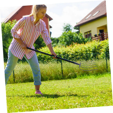 Person using Heavy Duty Garden Fork For Farm Cleanup And Mulching in yard, demonstrating versatility on grass surface