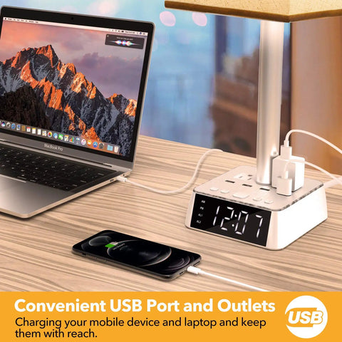 All In One Bedside Lamp With 4 USB Ports And AC Outlets, Alarm Clock Base, Square Oatmeal Fabric Shade on a desk with laptop and phone
