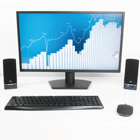Desktop setup with compact 2.0 computer speakers, monitor displaying graph, keyboard, and mouse. Compact 2.0 Computer Speakers With Full Stereo Sound, Easy Setup And Convenient Controls, Space Saving Desk Audio, Plug And Play 3.5mm Audio Jack For Laptops And Desktops.