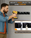 Person installing Heavy Duty ABS Plastic Broom Holder With Five Auto Adjustable Slots And Six Retractable Hooks on wall