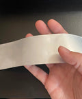 Person holding 2 Inch By 1000 Foot 5 Mil Detectable Safety Tape Red With Black Print Caution Buried Electric Line Below