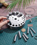 20 Size Steel Disc Cutter Set For Jewelry Making on a craft table with punch tools and metal materials.