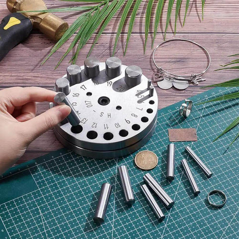 20 Size Steel Disc Cutter Set For Jewelry Making on a craft table with punch tools and metal materials.