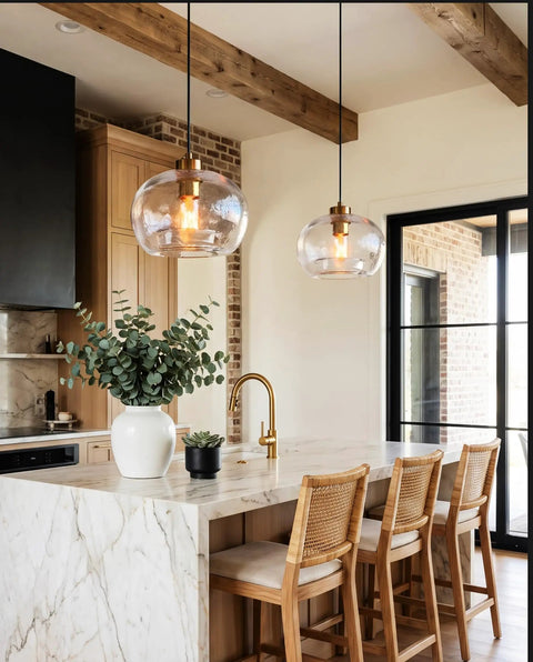 CASAMOTION Glass Pendant Lights, Textured Clear Globe Shade hanging above a kitchen island with wood beams and a marble countertop.
