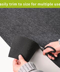 Person cutting oil spill mat for garage floor under car 96 by 48 inches absorbent with waterproof backing protects concrete epoxy and tile.
