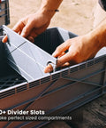 Hands inserting a divider into the Holy Grail Stackable Storage Bins With Lids And Dividers For Closet And Garage Organization.