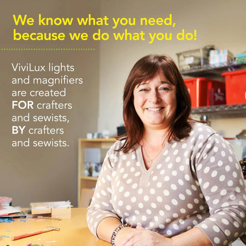 Woman in a crafting room with ViviLux product slogan on wall behind her; Pro Grade Optical 3X Magnifier With Handi-Clip visible on table.