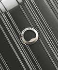 Close-up of brushed charcoal hardside luggage with DELSEY PARIS circular logo emblem