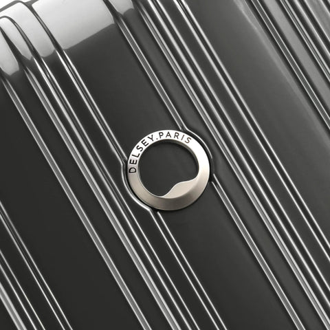 Close-up of brushed charcoal hardside luggage with DELSEY PARIS circular logo emblem