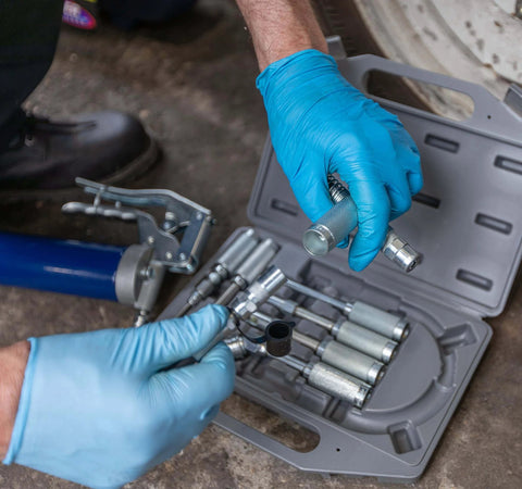 Versatile Grease Lubrication Adapter Kit With 12 Inch Hose And Quick Connect Couplings in use, displayed in a tool case.