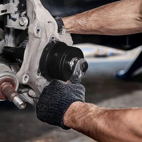 Mechanic using master wheel hub and bearing remover and installer kit for front wheel drive vehicles with nine step sleeves and washers.