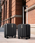 Two 16 Inch Expandable Underseat Carry-On Luggage With Wheels in Jet Black, displayed outside a brick building on a sunny day.
