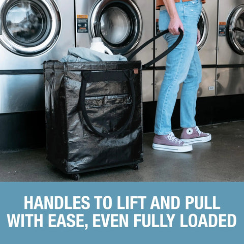 Person using 90L Collapsible Rolling Tote With Wheels For Groceries And Laundry in a laundromat, fully loaded, sturdy black design.