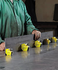 Magswitch mini multi-angle welding magnet; yellow housings with black knobs mounted on a steel plate (five units)