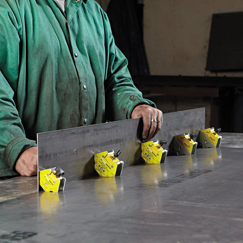 Magswitch mini multi-angle welding magnet; yellow housings with black knobs mounted on a steel plate (five units)