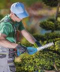 Person using Cordless Hedge Trimmer With Battery And Charger 21V Two In One Grass Cutter And Shrub Trimmer for bush trimming.