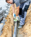 Worker using twenty pack of 24 inch straight rebar stakes with one half inch diameter steel for heavy duty ground anchors in landscaping