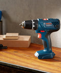 Real Deal 18V Cordless Drill Driver With 55Nm Torque And Quick Release Chuck on a wooden workbench, close-up view.