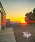 Sunset over a rural industrial building with the Hareline logo visible on the ground.