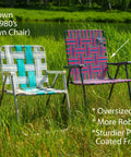 Retro webbed camping chair alongside vintage chair on grassy field