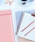 Light Pink 8.5 By 12 Inch Bubble Mailers Self Seal Padded Envelopes Air Cushioned Waterproof Lightweight Shipping Bags Usable 8.5 By 11 Space Pack Of 100 For Easy Hassle Free Shipments next to notepad and pens.