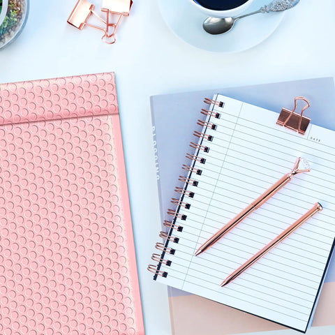 Light Pink 8.5 By 12 Inch Bubble Mailers Self Seal Padded Envelopes Air Cushioned Waterproof Lightweight Shipping Bags Usable 8.5 By 11 Space Pack Of 100 For Easy Hassle Free Shipments next to notepad and pens.