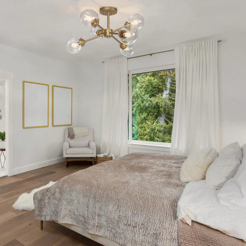 Lit Gold Semi Flush Mount Chandelier in modern bedroom setting, featuring candle style orbs in chic glass, 25.2 inches wide by 13 inches high