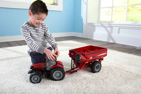 Child playing with Big Farm Tractor Toy For Kids With Realistic Lights And Sounds Opening Hood Removable Front Weights Red Indoor Play