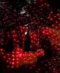 Bluetooth Motion Laser Lights With Dope 7 Color Full Spectrum White Star Effects illuminating an outdoor structure in red