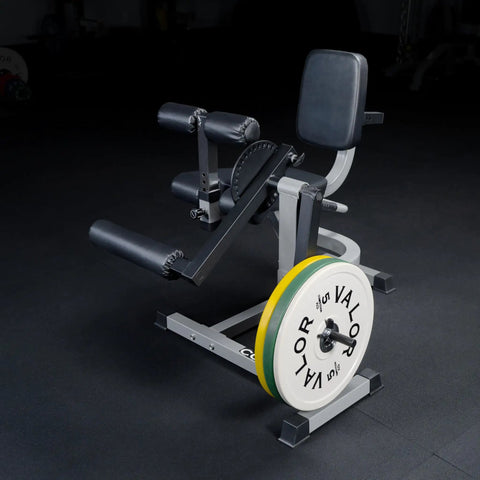 Leg Extension And Leg Curl Machine For Home Gym Adjustable with weights, steel frame, and padded seat in gym setting.