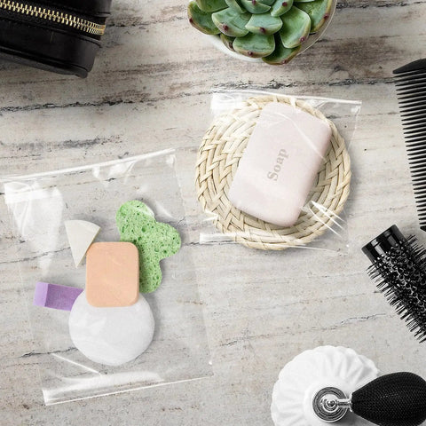Crystal Clear 11x14 Self Sealing Sleeves Pack Of 100, 1.6 Mil Acid Free Resealable Bags with toiletries and comb on table